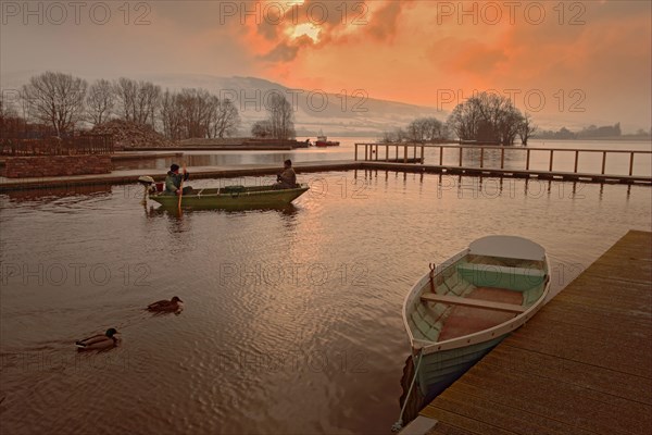 Anglers in a boat at dawn on the lake