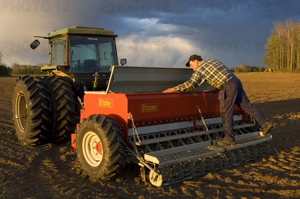 Farmer loading Tume seed drill