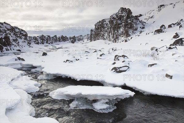 Oexara River flowing through Almannagja Gorge in the snow in winter