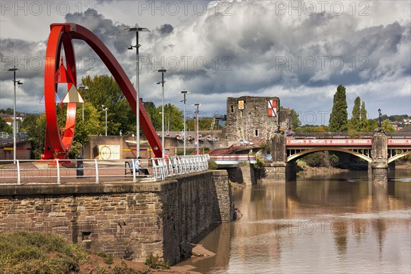 View of a steel sculpture on the waterfront with castle and bridge in the background