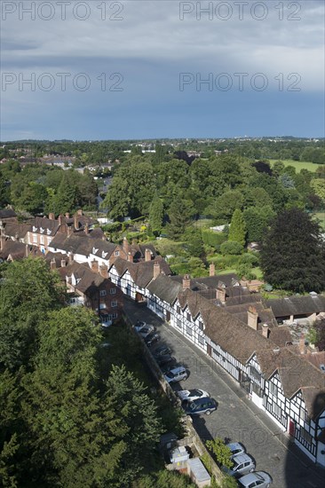 View from castle overlooking trees and town with old Tudor timber-framed buildings lining street
