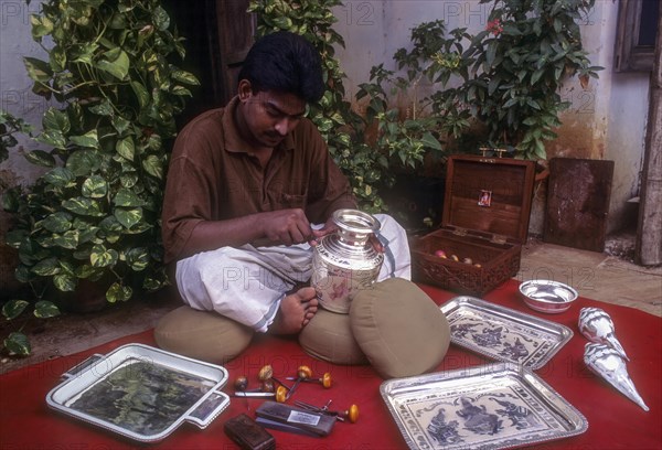 A silversmith carving on Silver utensil in Chettinad