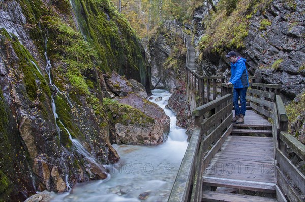 Tourist looking at the waterfall in the Wimbachklamm gorge in Ramsau bei Berchtesgaden