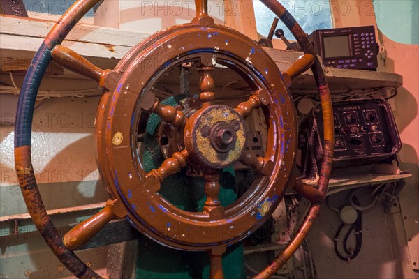 Wooden steering wheel on the bridge of a fishing boat at the Port Musee