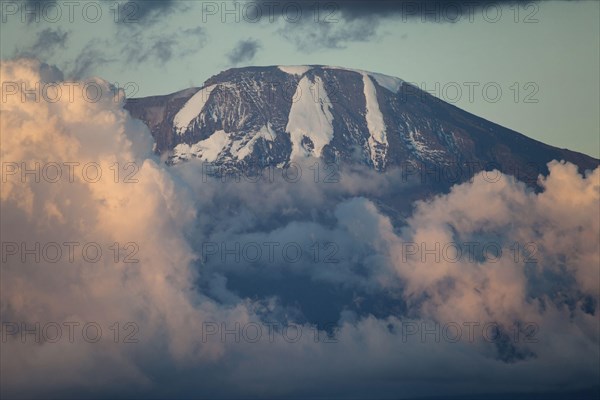 View of mountain summit with clouds at sunset