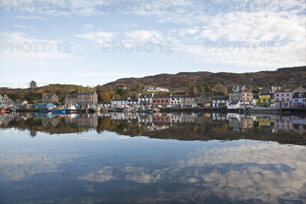 View of boats moored at town harbour in sea loch