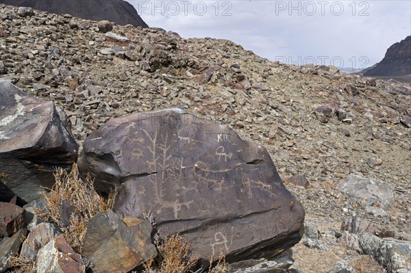 Ancient petroglyphs depicting animals and people hunting