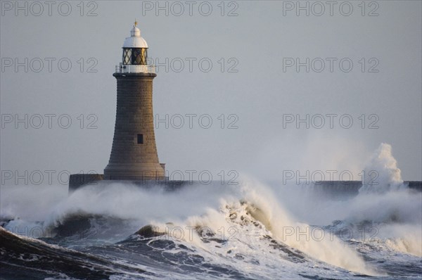 Rough sea and breakwater with lighthouse