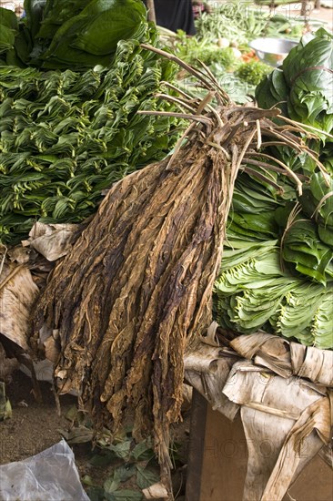 Dry tobacco leaves resting on beetle leaves at a market in Sri Lanka