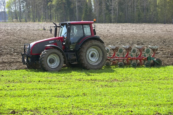 Valtra tractor ploughs field with four-furrow reversible plough