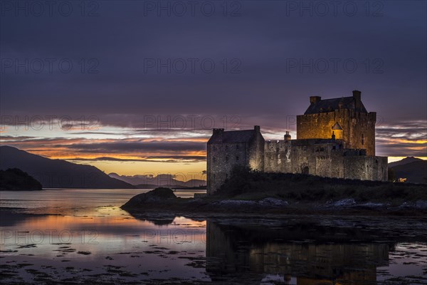 Illuminated Eilean Donan Castle at sunset in Loch Duich