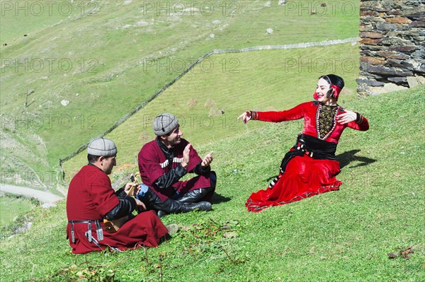 Georgian people from a folkloric group playing panduri and dancing in traditional Georgian dress