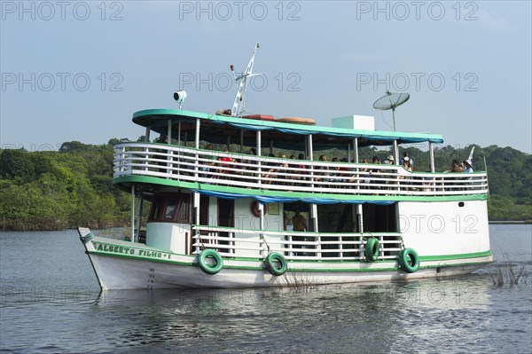 Traditional wood boat navigating with tourists on the Rio Negro