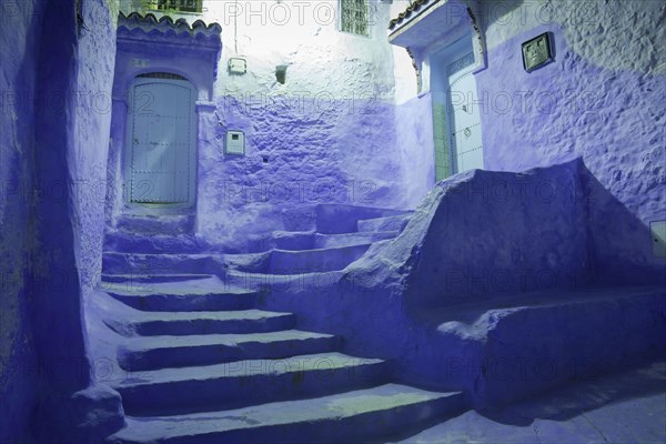 Blue doors and staircase in a city avenue at night