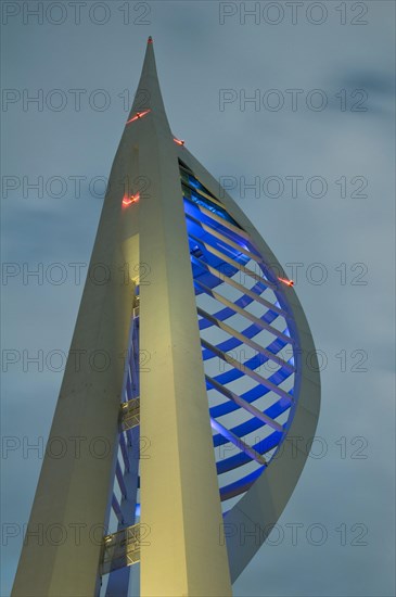 Spinnaker Tower illuminated under stormclouds at dusk