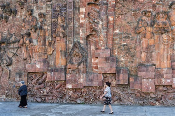 Close-up of communist-era faces on the facade of the city market