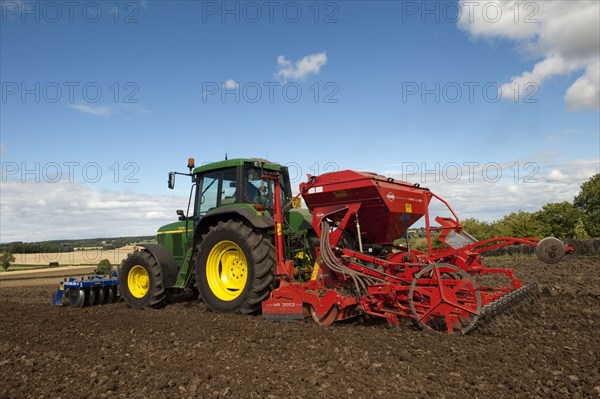 John Deere tractor with front press and rear seed drill