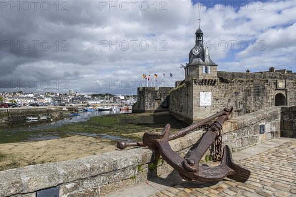 Old anchor and bell tower at the entrance gate to the medieval Ville Close in Concarneau