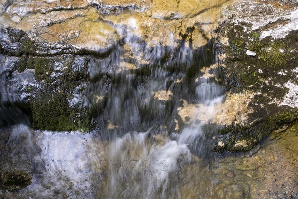 Water from a mountain stream flowing over stones on the Postalm in the Salzkammergut