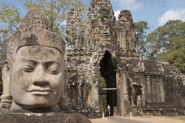 Sculpture of a head next to the road to the gate tower of the Khmer temple