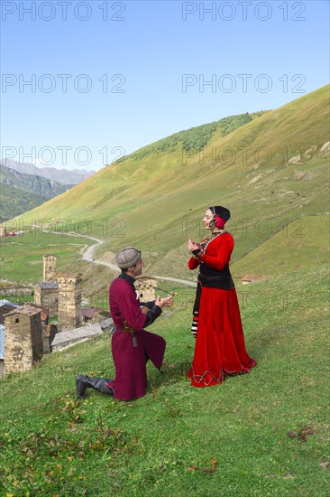 Georgian people from the folklore group playing panduri and dancing in traditional Georgian dress