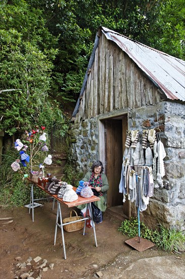 Woman sitting in front of stone house