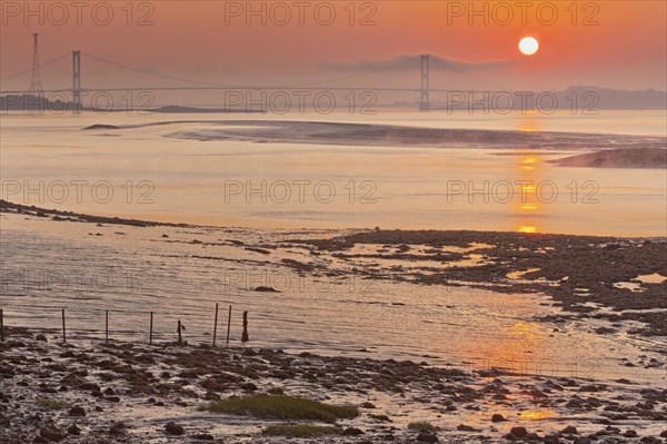 View across the estuary towards the suspension bridge in the mist at dawn