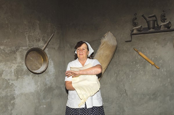Armenian woman preparing Armenian lavash bread in the traditional tandoor oven