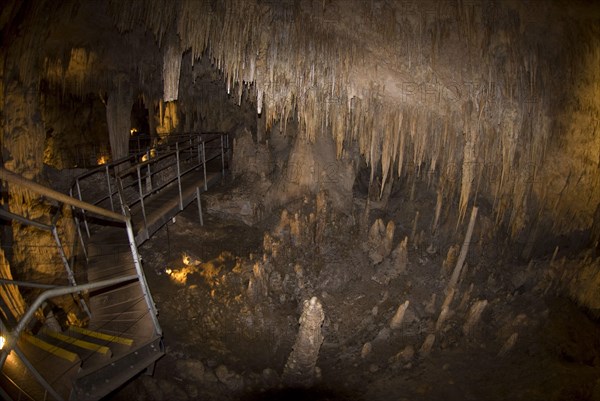 Steps and promenade through a cave with stalactites and stalagmites