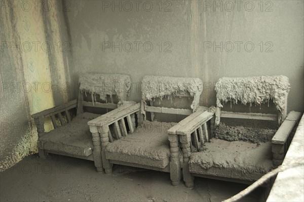 Ash-covered chairs in a house damaged by the recent volcanic eruption