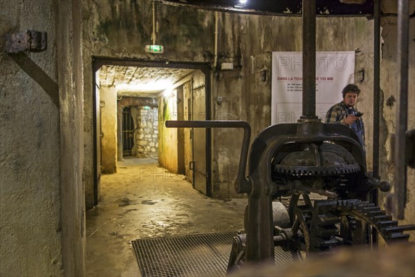 Visitors with audio guide in the 155 mm gun turret inside the First World War Fort de Douaumont