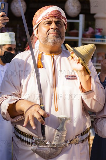 Man performing traditional songs during the Friday Goat Market in Nizwa