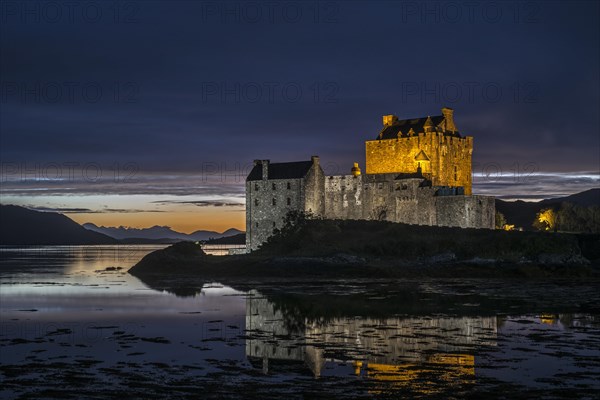 Illuminated Eilean Donan Castle at night in Loch Duich