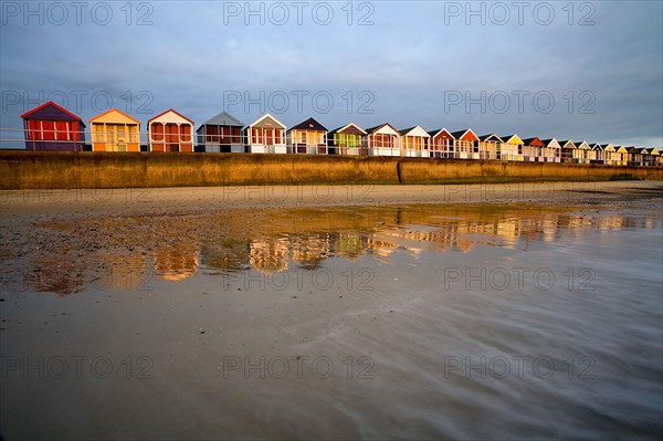 Beach huts on the seaside resort dyke at sunrise