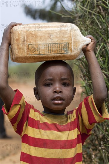 Children collecting water from a well and carrying it home