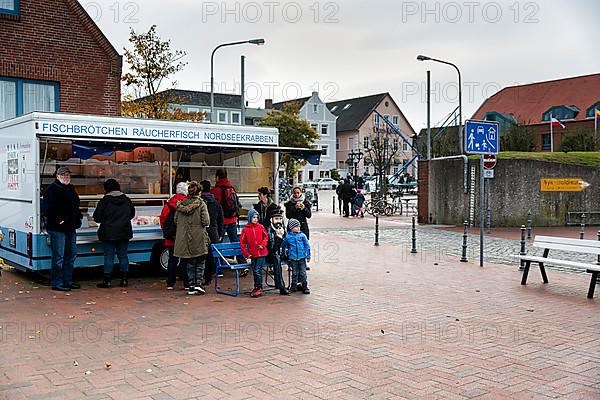 Customers at a sales cart for fish rolls