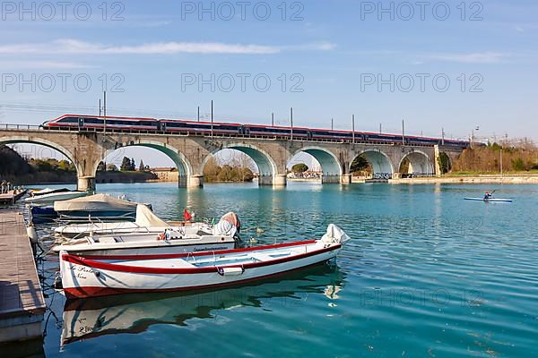 Frecciargento FS ETR 700 high speed train of Trenitalia on a bridge over the river Mincio in Peschiera del Garda