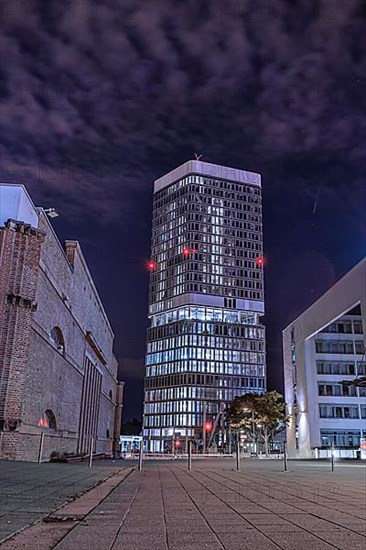 View of high-rise building through street at night