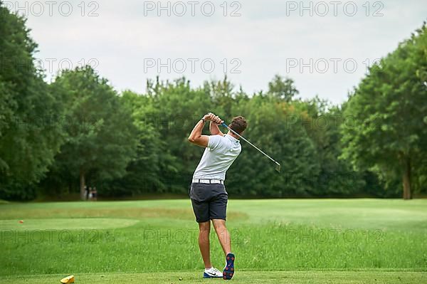 Golfer teeing off a ball