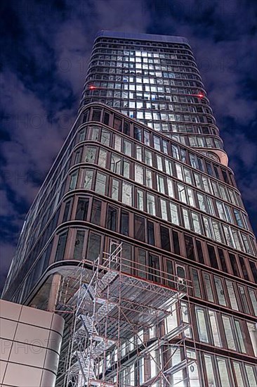 High-rise building at night with scaffolding