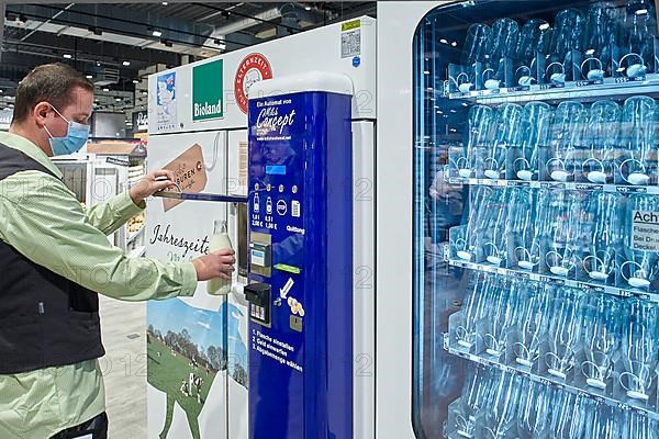 Man draws milk from a vending machine