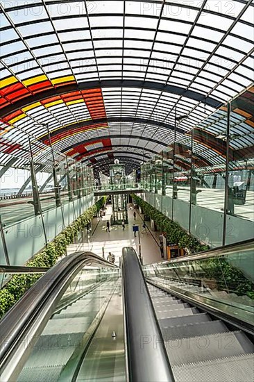 Escalators at a futuristic bus station with glass roof