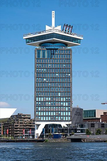 High-rise building with a swing on the roof by the city canals