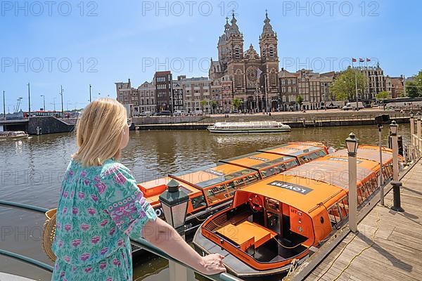 Woman overlooking tourist boats and the cathedral over the canals