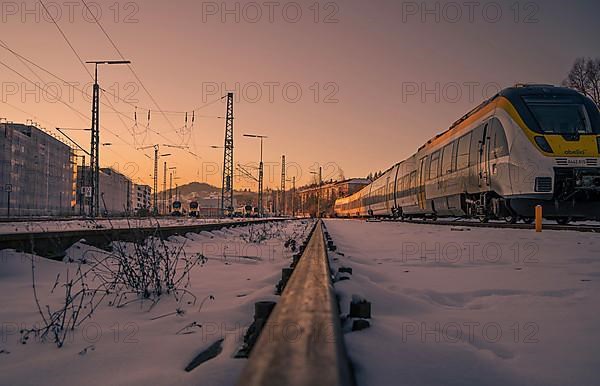 Sunset at the railway tracks with train in the background