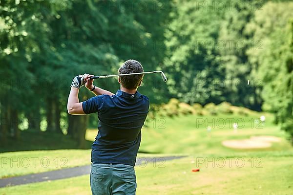 Golfer teeing off a ball