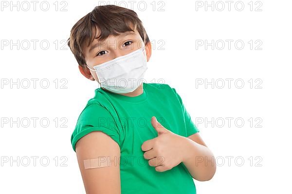 Child boy with plaster at children vaccination mask showing thumbs up against corona virus corona virus isolated exempt in Stuttgart