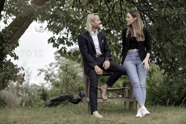 Man and woman talking on a wooden table in nature