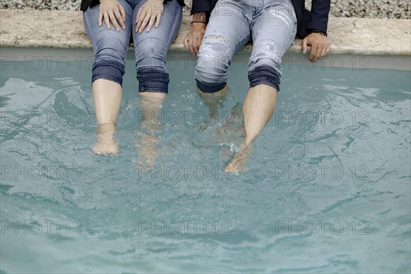 Four legs in jeans in the swimming pool