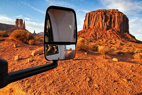 Motorhome on gravel road in front of striking rock formation